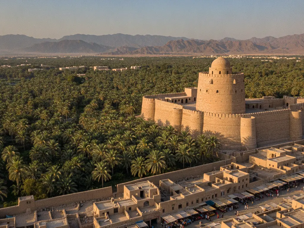 Nizwa Fort's massive circular tower overlooking date palms and the old souq below.